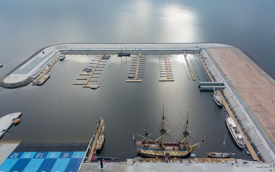 Russia, St. Petersburg, 14 October 2021: Aerial view of the new port Hercules with a replica of the old military frigate Poltava, the port next to the Lakhta center skyscraper. High quality photo