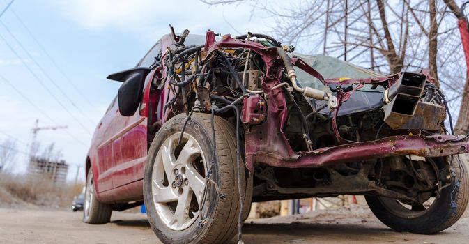 Close up of broken and abandoned car. Smashed car to pieces after accident on street. Concept of careless driving