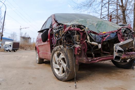 Close up of broken and abandoned car. Smashed car to pieces after accident on street. Concept of careless driving