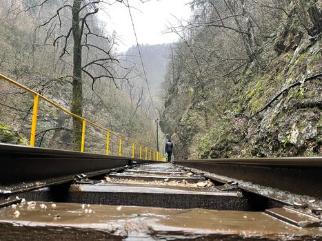 Close up of railway in mountainous terrain. Railway track in rainy weather in amazing and mysterious nature