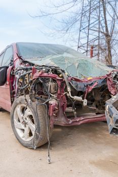 Close up of broken and abandoned car. Smashed car to pieces after accident on street. Concept of careless driving