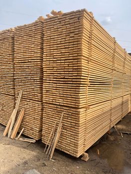 Close up of wooden boards on background of blue sky. Industrial natural timber building materials on building site