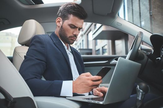 Confident businessman. Businessman with laptop in the car