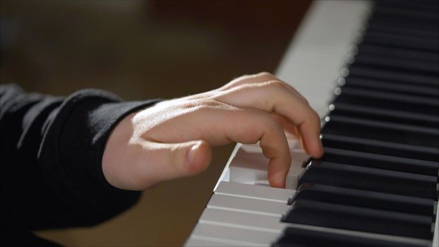 The musicians are playing a big black keyboard. Big hands on the keys of the synthesizer. The musician plays the keyboards.