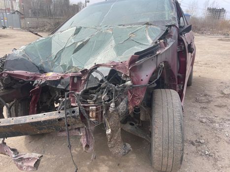 Close up of broken and abandoned car. Smashed car to pieces after accident on street. Concept of careless driving