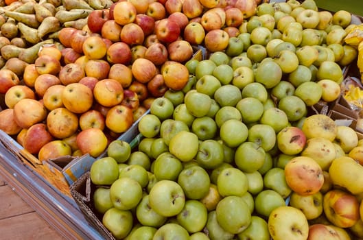 Ripe apples in a box. Fresh green and red apples on the counter in the supermarket.