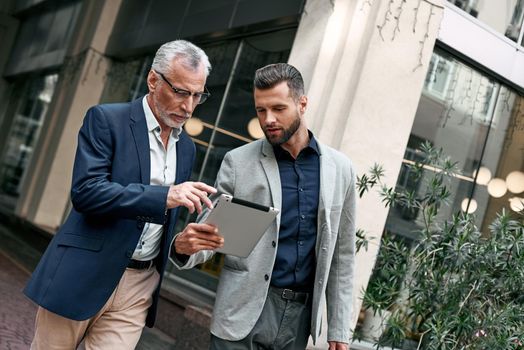 Businessman And Businesswoman Using Digital Tablet Outside