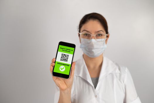 The doctor recommends vaccination and holds a smartphone with a QR code