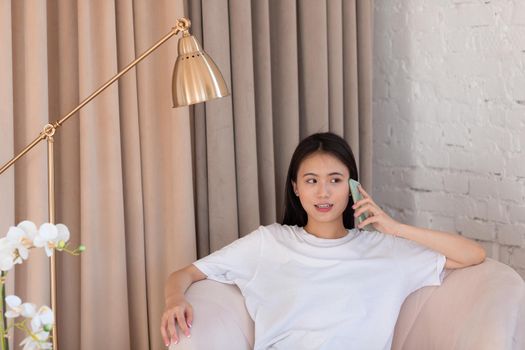 Portrait of asian woman enjoying using mobile phone at apartment interior indoor living room