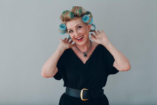 Elderly old aged woman housewife with curlers rollers on hair head.