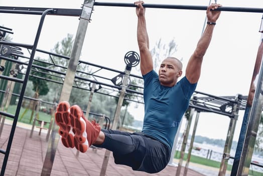 Young male jogger athlete training and doing workout outdoors in city.