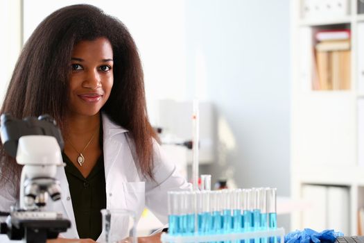 Black female chemist student conducting research using a microscope for bacterial contamination of water searching for a vaccine to treat diseases in medicine doctor concept