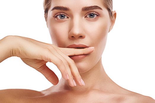 Beautiful woman bites her finger close-up studio photo on white background. Light hair, grey eyes, nude