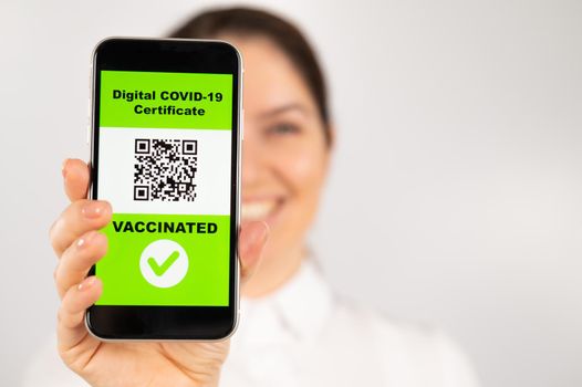 Woman showing smartphone with qr code about vaccination