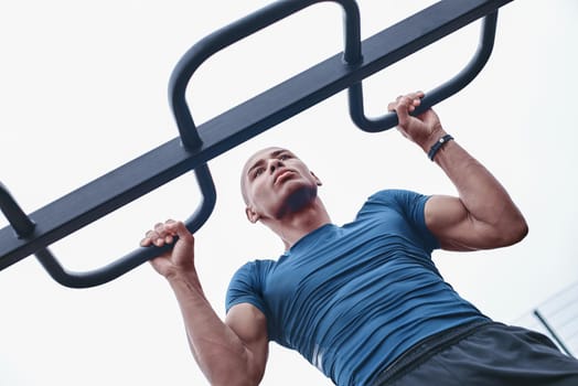 Young male jogger athlete training and doing workout outdoors in city.