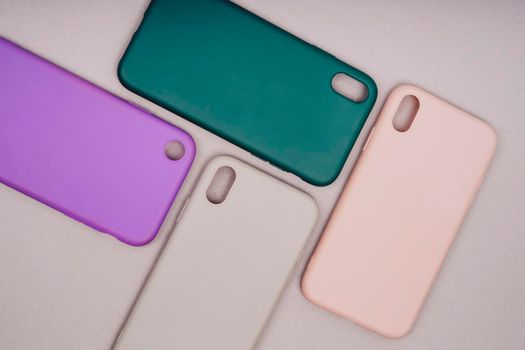 A few silicone cases for the smartphone. The phone is in a gray case. Purple, grey, green and pink smartphone cases. Protect your phone.