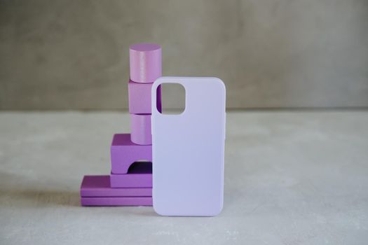 Purple wooden figures and purple silicone case for smartphone. Wooden cubes. Abstract background.