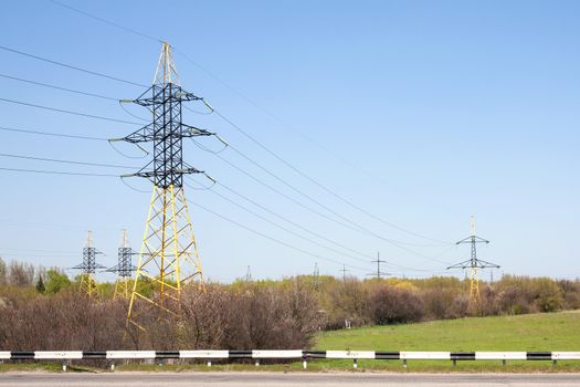 High-voltage power lines on a blue sky background. City infrastructure.