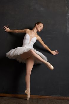 woman ballerina in a white tutu dance posing performance dark background. High quality photo