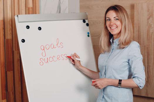 Business woman young adult coach at office with whiteboard