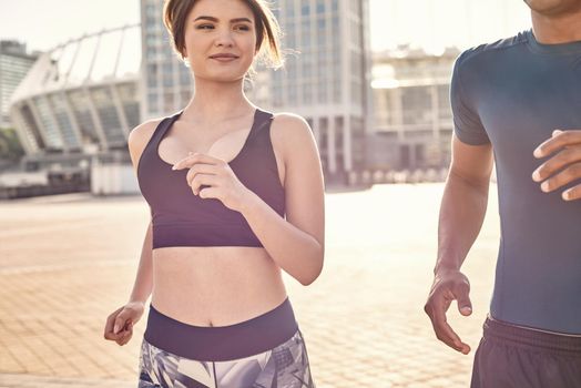 Beautiful multiracial couple of young athletes running together on a sunny warm day. Common hobbies. Healthy couple. Sport motivation concept. Fitness concept. Women beauty. Healthy life. Exercising together