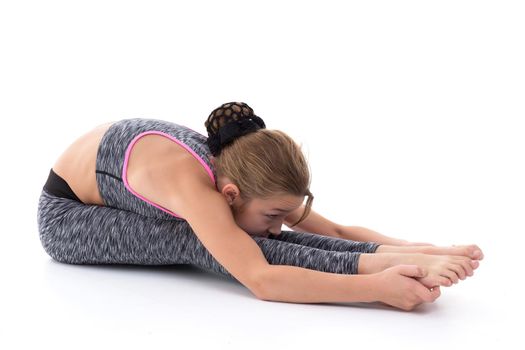 A girl gymnast performs an acrobatic element on the floor. The concept of childhood, sport, healthy lifestyle. Isolated on white background.