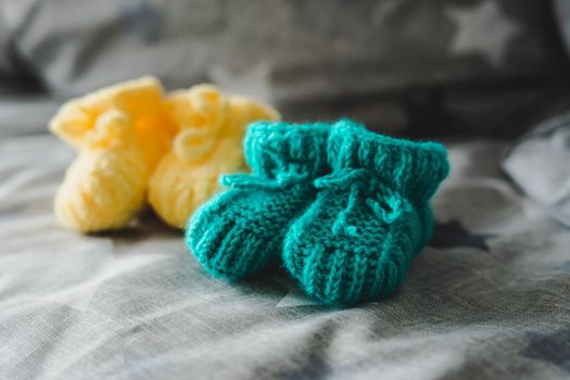Mint and yellow knitted booties for a child. Knitted socks for the baby.