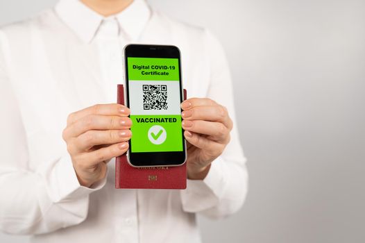 Woman holding passport and phone with qr code about vaccination
