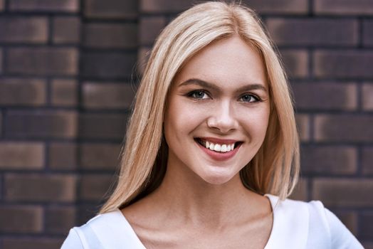 Beautiful blonde woman smiling politely facing the camera