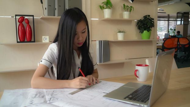 businesswoman drawing on paper sketch sitting at the desk. holding line and pencil