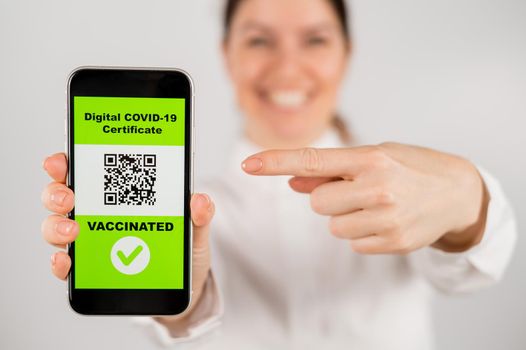 Woman showing smartphone with qr code about vaccination