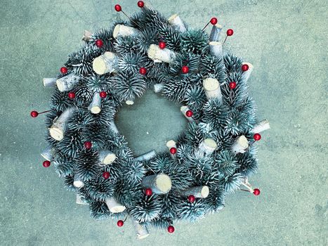Christmas wreath made of pine cones on a concrete background, horizontal photo in cold silver colors.