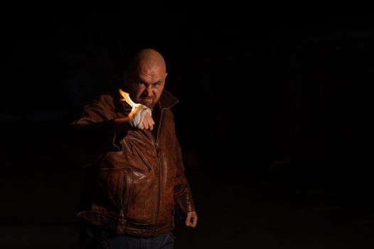 Bald Caucasian man beats with a burning fist