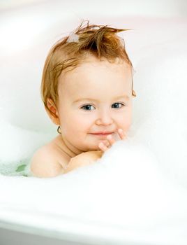 little smiling baby sitting in the bath