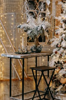 Home Christmas interior, with a Christmas tree and lots of glowing garlands and light bulbs. Preparing for the Christmas party at home.