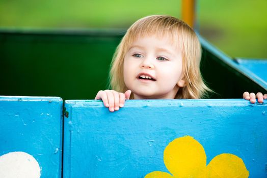 Portrait of two-year child at playground area in summer