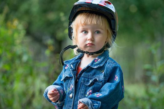 Cute little girl with sport helmet for bicycle, roller or skate