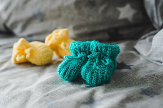 Mint and yellow knitted booties for a child. Knitted socks for the baby.
