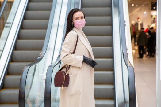 portrait of middle aged woman with gloves and mask on escalator in public place