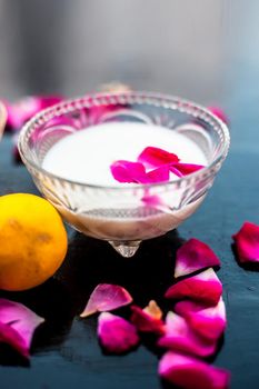 Milk face pack in a glass bowl used for brighter skin on wooden surface consisting of raw milk,honey and lemon juice.