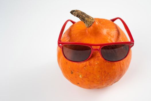 Pumpkin in sunglasses on a white background. Halloween symbol. Isolate