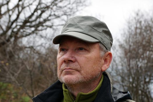 portrait of an older man in a cap on the background of nature.