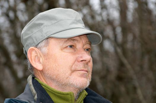 portrait of an older man in a cap on the background of nature.