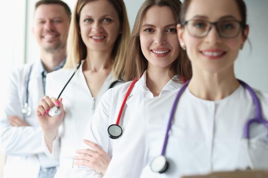 Group of joyful practicing young doctors in uniform, close-up. Hospital first aid, medical professional