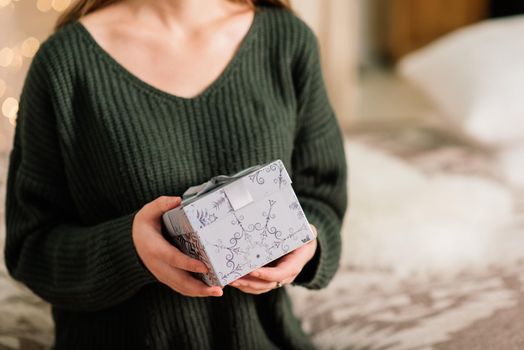 Beautiful young woman celebrating christmas at home, having fun opening presents