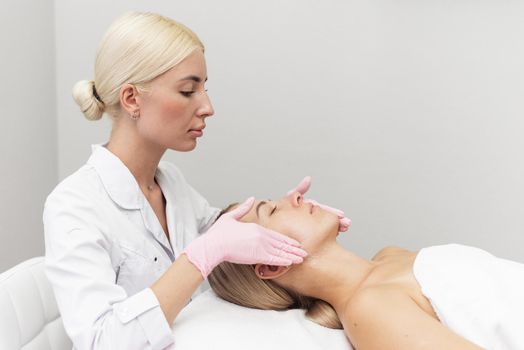 Woman is having cosmetic treatment at spa salon. Facial massage with foam to remove dead skin.