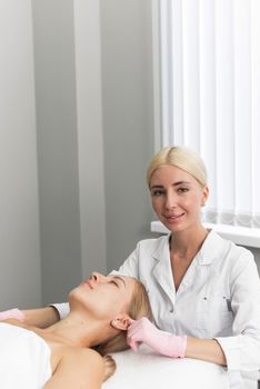 The beautician looks at the camera. Visit to the beautician and spa center. Cute beautician with a smile on his face looks directly into the camera.