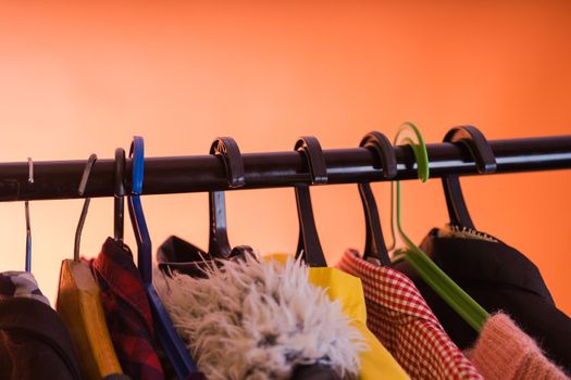 Close up of hangers with clothes on orange background
