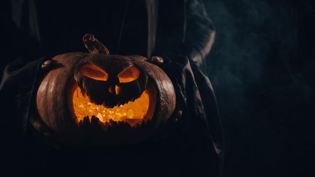 The witch is holding a pumpkin jack about a lantern glowing in the dark. Halloween