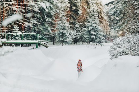 Portrait of a woman in gray clothes in a winter forest.Girl in the new year's snow-covered forest